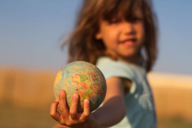 Une fillette porte la terre dans sa main : concept d'épargne responsable